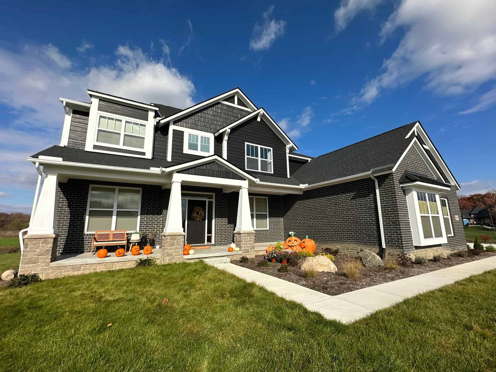 Closer view from the side of the black house. It surrounded by grass.
