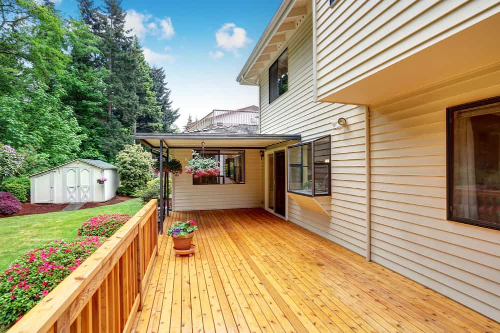 Wooden walkout deck. Well kept garden with bushes and flowers. Northwest, USA