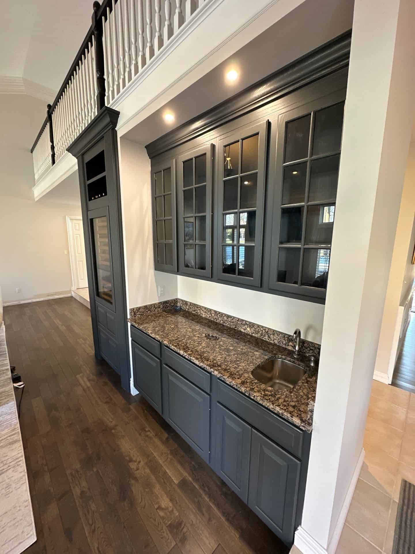 Gray kitchen cabinets with epoxy countertop.